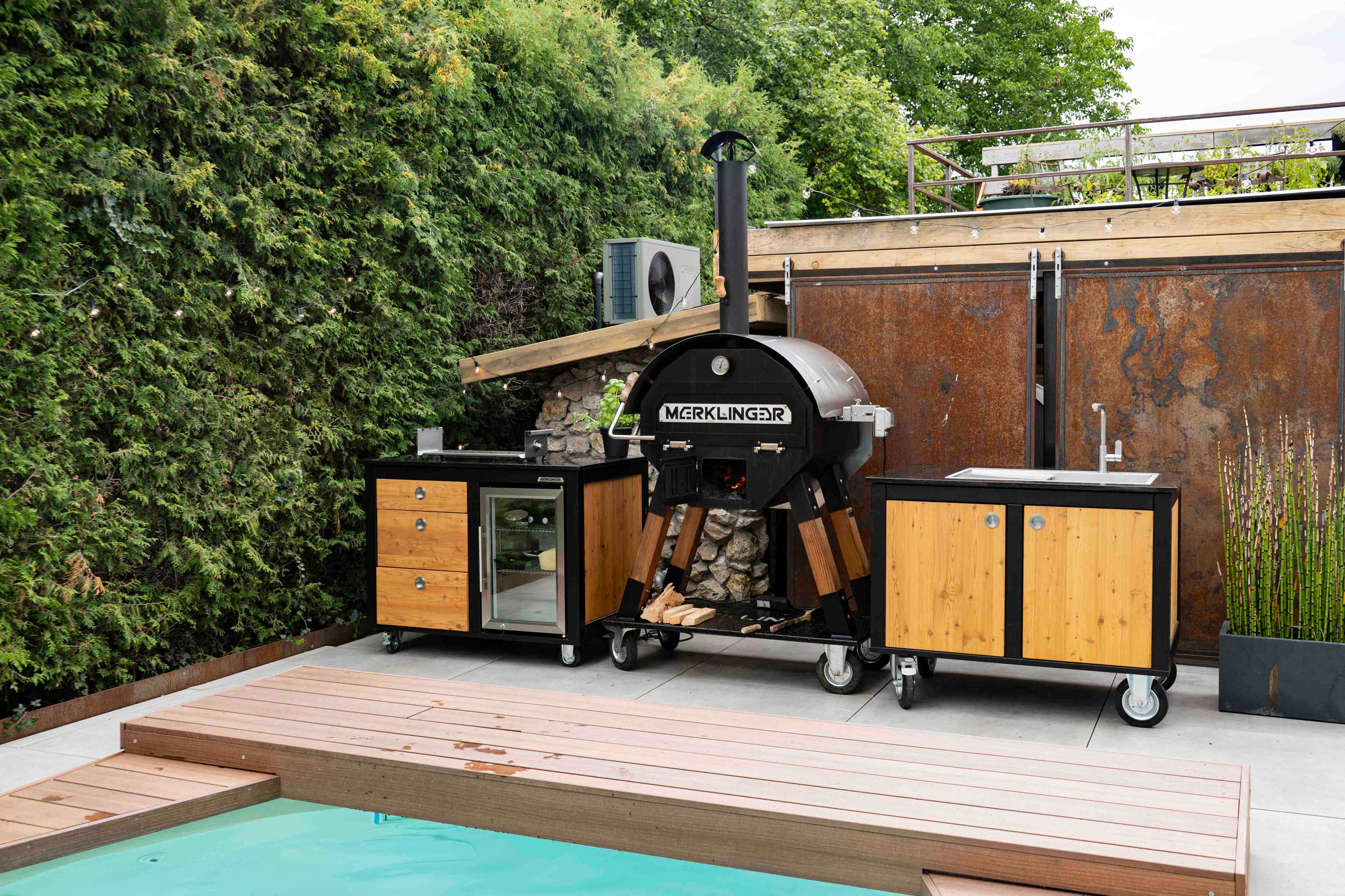 Merklinger Poolterrasse mit MERKLINGER Holzofen sowie Kühl- und Spülmodul auf Rollen