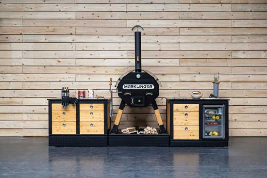 Merklinger Outdoor-Küchenzeile mit MERKLINGER Rundofen; links Schubladenmodul LOTTI, rechts Schubladen- und Kühlmodul mit Glasfront