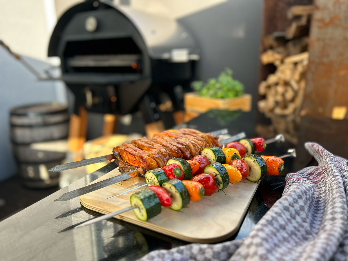 Grill Spieße auf Holzbrett mit Merklinger Backofen im Hintergrund