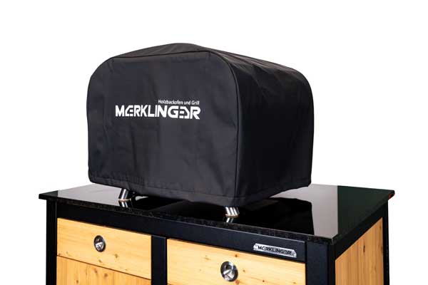 „Schutzhülle für MERKLINGER Holzbackofen und Grill aus wasserabweisendem, schwarzen Gewebe mit großzügigem Logo.“