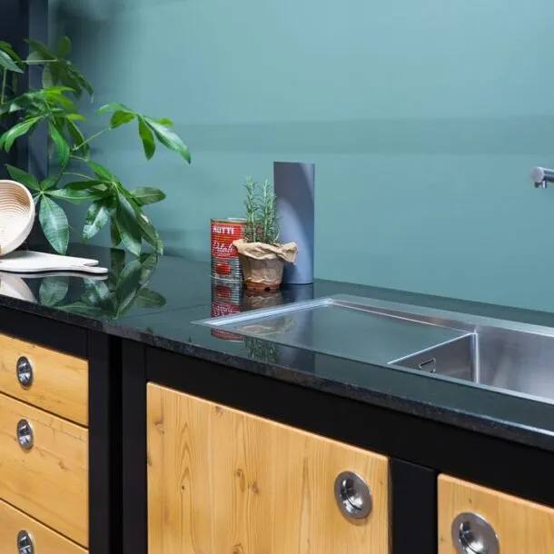 Granit-Arbeitsplatte mit Edelstahl-Spüle, Pflanzen und Gewürzdosen im Outdoor-Modul.