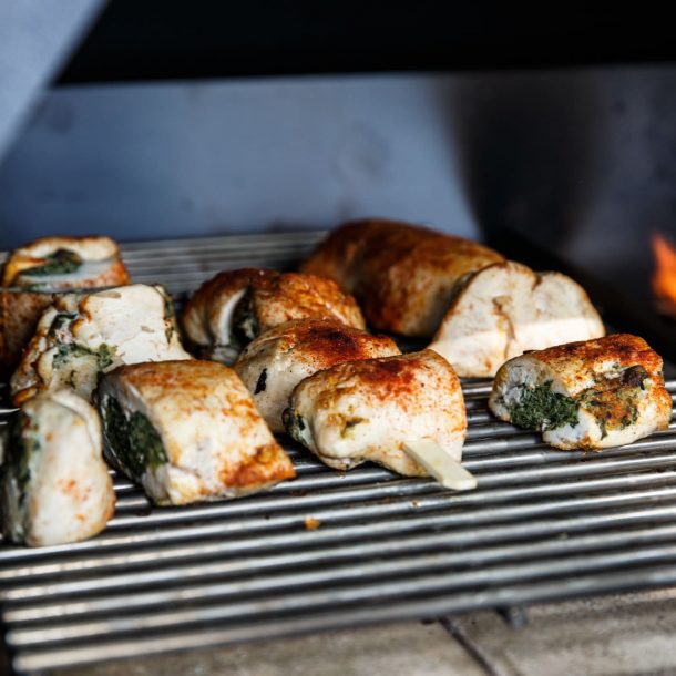 Würzige Hähnchen-Spießröllchen auf Edelstahlrost im MERKLINGER Grill.“ Würzige Hähnchen-Spießröllchen auf Edelstahlrost im MERKLINGER Grill.“